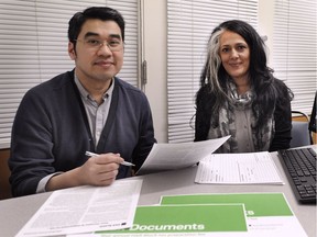 James Kim and Judy Bhuller, district manager from H&R Block, review files Sunday on the last day of a week-long tax clinic at the Carnegie Centre at Main and Hastings in Vancouver.