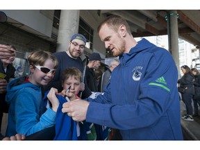 Zach (left) and his brother Harrison Kobos meets with Vancouver Canucks Henrik Sedin prior to their NHL game against the Columbus Blue Jackets in Vancouver, BC, March, 31, 2018.