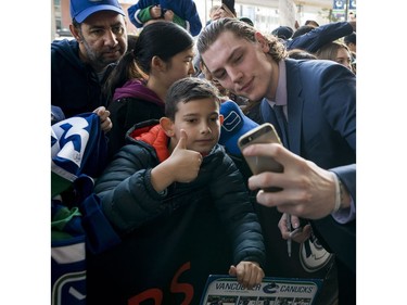 Vancouver Canucks Adam Gaudette takes a picture with a young fan Dennis Atanasov prior to their NHL game against the Columbus Blue Jackets in Vancouver, BC, March, 31, 2018.