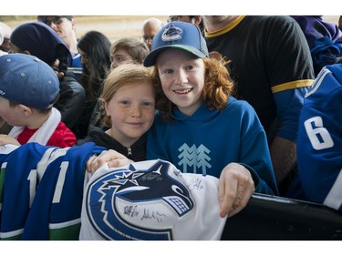 Vancouver Canucks fans Lily  (right) and Marin Carlos smile after getting their jerseys signed by Vancouver Canucks Brandon Sutter prior to their NHL game against the Columbus Blue Jackets in Vancouver, BC, March, 31, 2018.