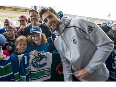 Vancouver Canucks fans Lily (centre) and Marin Carlos along with their dad Chris gets their picture taken with Vancouver Canucks Brandon Sutter  prior to their NHL game against the Columbus Blue Jackets in Vancouver, BC, March, 31, 2018.