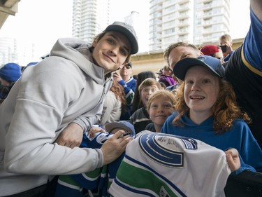 Vancouver Canucks fans Lily (right) and Marin Carlos along with their dad Chris gets their picture taken with Vancouver Canucks Jake Virtanen  prior to their NHL game against the Columbus Blue Jackets in Vancouver, BC, March, 31, 2018.
