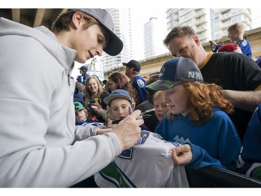 Vancouver Canucks fan Lily Carlos gets a jersey signed by Vancouver Canucks Jake Virtanen prior to their NHL game against the Columbus Blue Jackets in Vancouver, BC, March, 31, 2018.