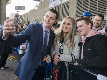 Vancouver Canucks Adam Gaudette (left) take a picture with  Janey Wilson (centre) and Matthew Jenkins prior to their NHL game against the Columbus Blue Jackets in Vancouver, BC, March, 31, 2018.