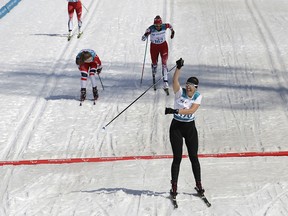 Gold medal winner Anna Milenina of the Paralympic Athletes of Russia, center, celebrates as she crosses the finish line ahead of silver medalist Vilde Nilsen of Norway, back left, and bronze medalist Natalie Wilkie of Canada, back right, in the final of the women's 1.5km sprint classic, standing, cross-country skiing at the 2018 Winter Paralympics in Pyeongchang, South Korea, Wednesday, March 14, 2018.