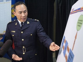 RCMP Insp. Henry Tso points to a chart as he speaks to the media after a news conference in Toronto on March 26, 2014.
