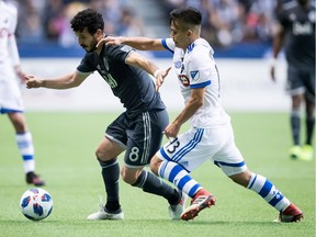 Vancouver Whitecaps' Felipe Martins (8) and Montreal Impact's Ken Krolicki (13) vie for the ball during the second half of an MLS soccer game in Vancouver, B.C., on Sunday March 4, 2018.