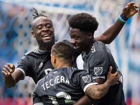 Vancouver Whitecaps' Kei Kamara, back left, Cristian Techera and Alphonso Davies celebrate Davies' goal against the Montreal Impact on Sunday March 4, 2018.