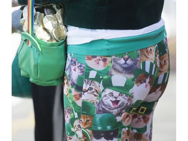A woman wearing  tights with green hatted cats and carrying a pot of gold purse attends St. Patrick's Day party at the Blarney Stone, Vancouver, March 17 2018.