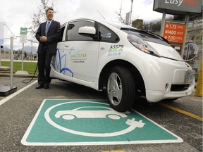 City council will vote this week on a bylaw amendment that would require all parking spots in new condos be equipped for electric vehicle charging. Mayor Gregor Robertson is pictured in this file photo posing with one of the city's electric vehicles and charging stations.