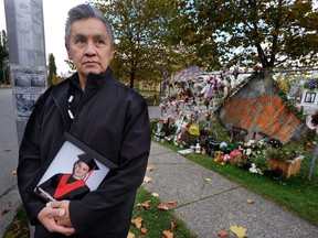 FILE PHOTO - Wayne Bell stands near a memorial for his son Devon Allaire-Bell six months after he was murdered, outside Surrey's Frank Hurt Secondary School. The 19-year-old boy mobbed and stabbed to death on Easter Sunday, 2011.