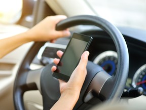 woman driver hand use her cell phone driving a car