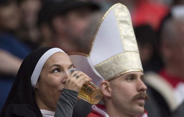 A rugby fan dressed as a nun drinks a beer during the World Rugby Seven Series at B.C. Place in Vancouver, Saturday, March, 10, 2018.