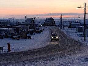 The sun rises as a car drives along a road in Iqaluit, Nunavut on Wednesday, December 10, 2014.