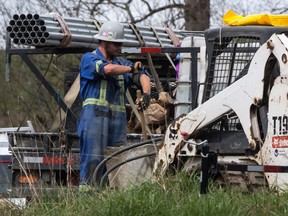 A worker rolls up his sleeves as work continues at Kinder Morgan's facility in preparation for the expansion of the Trans Mountain pipeline, in Burnaby on April 9. The Houston, Tex.,-based firm announced Sunday it has suspended all non-essential activities and related spending on the pipeline expansion that would carry Alberta bitumen to an export terminal near Vancouver.