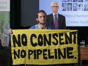 Trans Mountain Pipeline protester Gabriel D'astous interrupts a speech by Natural Resources Minister Jim Carr at the "Positive Energy" conference at the University of Ottawa on Monday, April 23, 2018.