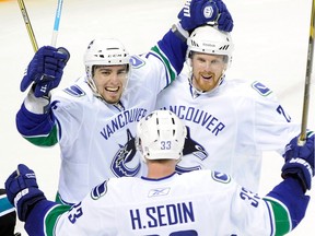 Alex Burrows, Henrik Sedin and Daniel Sedin celebrate Burrows' goal in the third period against the San Jose Sharks in Game Four of the Western Conference Finals during the 2011 Stanley Cup Playoffs.