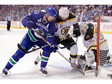 JUNE 15:  Daniel Sedin #22 collides with Johnny Boychuk #55 of the Boston Bruins during Game Seven.