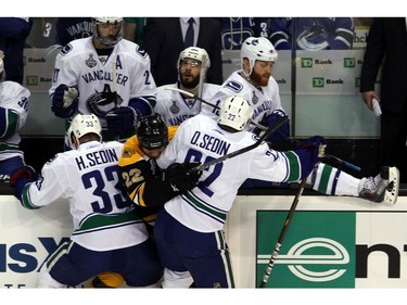 JUNE 13:  Shawn Thornton #22 of the Boston Bruins gets checked by Henrik Sedin #33 and Daniel Sedin #22 of the Vancouver Canucks during Game Six .