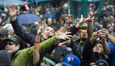 Hands reach out for free cannabis products tossed to the crowd gathered at Sunset Beach for the annual 4/20 protest in Vancouver.