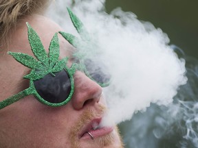 A man smokes a joint as cannabis enthusiasts gather at Sunset Beach for the annual 4/20 protest in Vancouver.