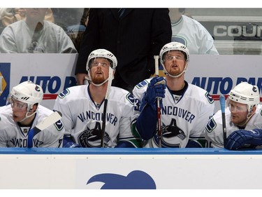 Dec. 15, 2007:  (L-R) Mason Raymond #21, Daniel Sedin #22, Henrik Sedin #33 and Matt Cooke #24 of the Vancouver Canucks look on from the bench area during their NHL game against the Edmonton Oilers. The Oilers defeated the Canucks 2-1 in shootout overtime.