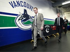 Daniel Sedin, left and Henrik Sedin of the Vancouver Canucks walk to their locker-room as they arrive at Rogers Arena before Tuesday's game against the Vegas Golden Knights.