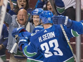 Daniel Sedin looks back at his brother after scoring a goal that was assisted by Henrik in the second period.