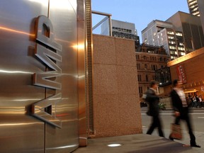Pedestrians walk past the headquarters of AMP Ltd. in Sydney. For their past sins, AMP and the big banks are now paying out more than A$200 million.