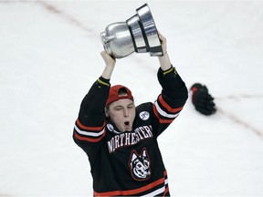 Northeastern forward Adam Gaudette (8) hoists the Beanpot trophy after defeating Boston University during the championship game of the Beanpot hockey tournament in Boston, Monday, Feb. 12, 2018. Gaudette earned a hat trick, scoring three times, in the 5-2 win.