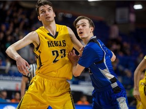 Jusuf Sehic, a 6-7 forward with the Burnaby South Rebels, left, battles for position with Lucas Gage of the Belmont Bulldogs during semifinal action in the quad-A B.C. provincial boys' basketball championship tournament at Langley Events Centre.