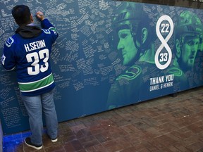 Vancouver Canucks' fan Kevin Kedin Madarita signs the Thank You Sedins wall in the Plaza outside Rogers Arenas on Thursday before the Canucks played — and beat — the Arizona Coyotes.