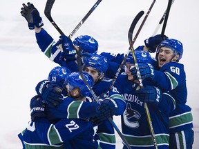 Daniel Sedin is mobbed after scoring in overtime Thursday.