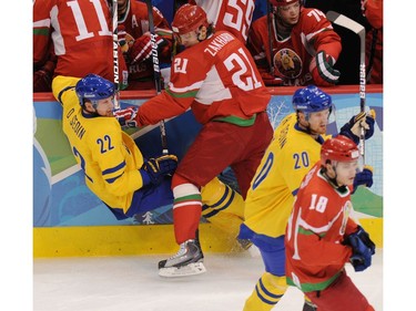 Feb. 19, 2010: Sweden's Daniel Sedin gets upended by Belarus's Konstantin Zakharov in the first period during Vancouver 2010 Olympic Winter Games men's hockey at Canada Hockey Place.