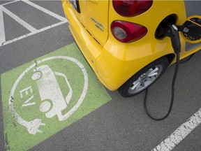 A electric car is seen getting charged at parking lot in Tsawwassen, near Vancouver B.C., Friday, April, 6, 2018.