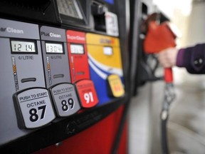 A motorist reaches for the pump at a gas station in Toronto on Thursday, February 24, 2011.