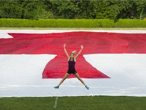Natasha Wodak jumps in front of the large 140 metres by 70 metres Canadian Flag laid on the rugby pitch at Brockton Oval.