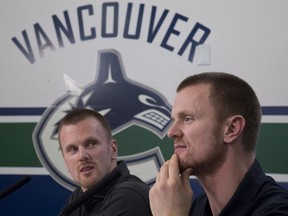 Vancouver Canucks' Henrik, right, and Daniel Sedin announce their retirements from hockey during a news conference at Rogers Arena in Vancouver on April 2.