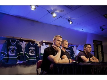 Sept. 28, 2014: Vancouver Canucks Henrik Sedin, left to right, Daniel Sedin and Alex Burrows talk to media during the first day of the team's training camp in Vancouver, B.C.