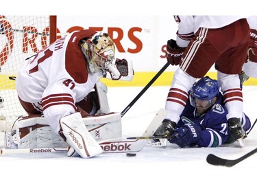 Dec 6. 2013:
Vancouver Canucks' Daniel Sedin (22) tries to move the puck as he lies on the ice but is stopped by Phoenix Coyotes goaltender Mike Smith (41).