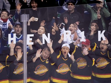 Fans spell out the name of Vancouver Canucks' Henrik Sedin, of Sweden, who scored against the Florida Panthers to record his 1,000th career point, during an NHL hockey game in Vancouver.