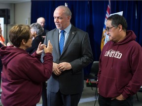 British Columbia Premier John Horgan, centre, speaks with church members after a housing announcement at a church in Coquitlam, B.C., on Friday April 13, 2018.