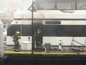Firefighters extinguish a fire that erupted Thursday morning on an 18-metre party boat docked at a Vancouver marina. [PNG Merlin Archive]