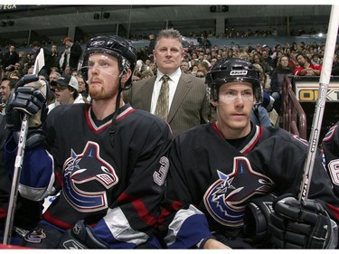 Dec. 17, 2005:  Head coach Marc Crawford  stands on the bench behind players Henrik Sedin #33 (L) and Brendan Morrison #7 during their game against the Edmonton Oilers at GM Place. The Oilers defeated the Canucks 5-4 in overtime.