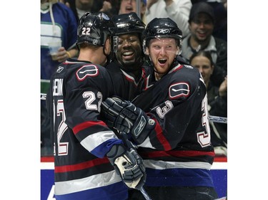 Oct. 1, 2005:  Left wing Daniel Sedin #22 and center Henrik Sedin #33 of the Vancouver Canucks celebrate with teammate right wing Anson Carter #77 after scoring against the Edmonton Oilers during their preseason game at GM Place.