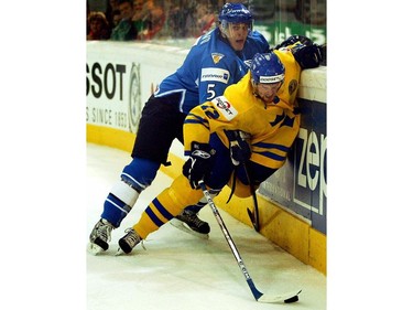 May 4, 2005: INNSBRUCK, AUSTRIA -- Pekka Saravo of Finland fights for the puck with Daniel Sedin of Sweden in the Group C match between Finland and Sweden the IIHF Men's World Championship, played in Innsbruck, AustriaAFP PHOTO - MARKUS LEODOLTER