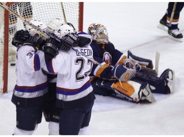 Feb. 18 2001: The Sedin twins hug Vancouver Canucks Murray Baron after he scored his third period game winning goal on  NY Islanders Rick DiPietro.