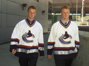 July 27, 1999: Newly signed Vancouver Canucks Daniel Sedin (blue shirt) and his twin brother Henrik (grey shirt) during  a news conference. The twin brothers said they will not play in the NHL this season.