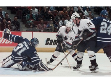 Oct. 16, 2000: Vancouver Canucks Daniel Sedin (centre #22) and Trent Klatt (#26) keep Toronto Maple Leafs goalie Curtis Joseph  (left #31) and Bryan McCabe (right #24) busy.