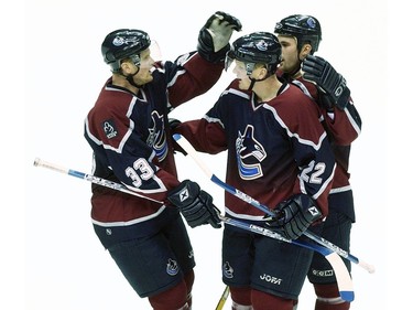 Oct. 20, 2003: Henrik Sedin (#33) celebrates with his twin brother Daniel Sedin (#22) and linemate Jason King (#17) after Daniel scored against the Buffalo Sabres during the first period of a regular season NHL game at GM Place.